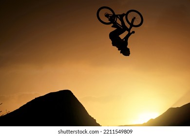 Cyclist, Fitness And Stunt Jump At Sunset In Colorado Countryside Nature Mountains In Fitness, Exercise Or Training. Danger Risk, Extreme Sports Mountain Bike Or Freedom Man In Sunrise Energy Workout