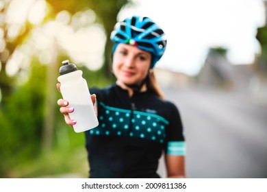 The cyclist holds the water bottle in her hand. Sports water bottle. The beautiful girl at thirst.sport, drinking, water bottle