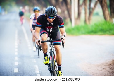 Cyclist Leads In Action,Front View Man Riding Bicycle In The Racing Road 