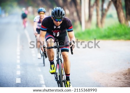 cyclist leads in action,Front view man riding bicycle in the racing road 