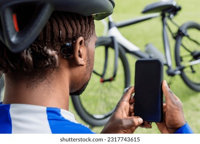 Cyclist looking at the phone as if looking for a map or a route. Sport and technology concept
