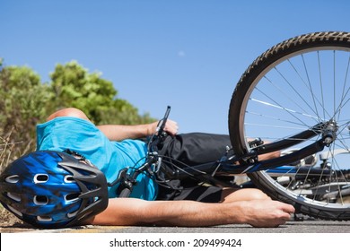 Cyclist Lying On The Road After An Accident On A Sunny Day