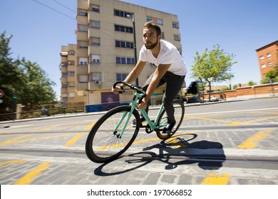 Cyclist man riding fixed gear sport bike in sunny day on a city
