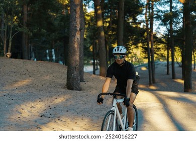 A Cyclist Navigates a Sandy Trail Surrounded by Tall Trees During Late Afternoon Light - Powered by Shutterstock