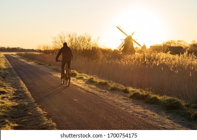 Cyclist On A Bike Lane In The Netherlands During A Spring Sunrise.