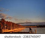 Cyclist on lake burley griffin in autumn with black mountain tower in the distance