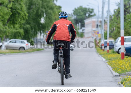 A cyclist on the road in the city. Rear view.