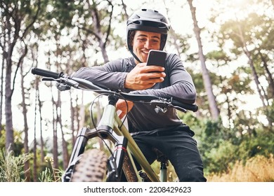 Cyclist, phone and bike happy in forest on ride for fitness, health and wellness. Man, smartphone and bicycle on social media or app for communication while in woods for adventure, workout and sport - Powered by Shutterstock