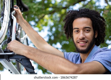 Cyclist Putting Bike On Car Roof