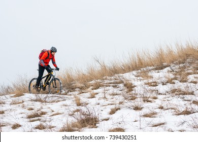 Cyclist in Red Riding the Mountain Bike on the Snowy Trail. Extreme Winter Sport and Enduro Biking Concept. - Powered by Shutterstock