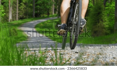 Cyclist Riding Bicycle on Gravel Road in Forest Slow Motion [[stock_photo]] © 