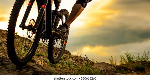 Cyclist Riding The Bike Down Rocky Hill At Sunset. Close Up Extreme Sport Concept. Space For Text.