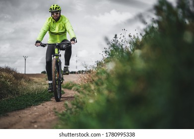 Cyclist riding a bike on the road. Nature and recreation. Hobbies and sports. Cyclist on summer ride. Dark clouds background.