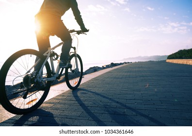cyclist riding bike in the sunrise coast path - Shutterstock ID 1034361646