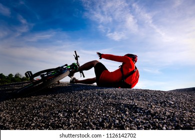 Cyclist riding mountain bike on the rocky trail at sunset,crashing on mountain bike.