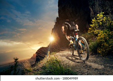 Cyclist riding mountain bike on trail at evening. - Powered by Shutterstock