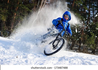 Cyclist Riding On A Mountain Bike In The Snow In The Winter Forest