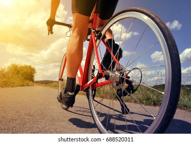 Cyclist riding on a road bike in the rural landscape at sunset. - Shutterstock ID 688520311