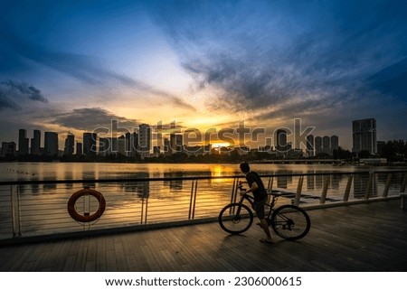 Cyclist at Riverside Walk of Singapore Sports Hub during sunset. It is a sports and recreation district in Kallang, Singapore. 