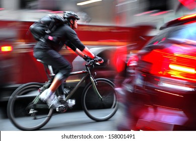 Cyclist In Traffic On The City Roadway Motion Blur