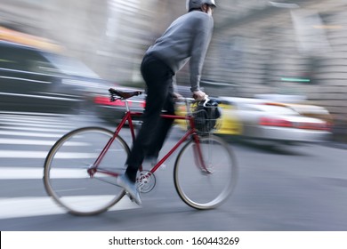 Cyclist In Traffic On The City Roadway Motion Blur