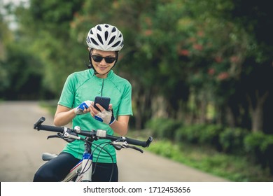 Cyclist use smartphone for navigation when riding mountain bike on forest trail - Powered by Shutterstock