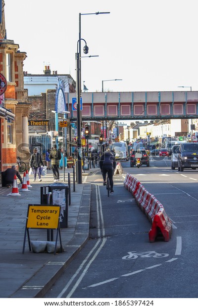 Cyclist using temporary cycle lanes in Shepherds\
Bush London UK December\
2020