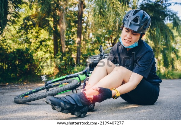 Cyclist woman having\
ankle pain after impact the floor by accident car crash on the\
road. Cycling injuries are an unfortunate part of most rider’s\
relationship with the\
bike.