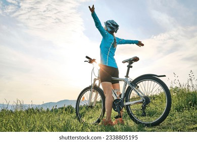 Cyclist Woman riding bike in helmets go in sports outdoors a mountain in the forest. Silhouette female at sunset. Fresh air. Health care, authenticity, sense of balance and calmness. - Powered by Shutterstock