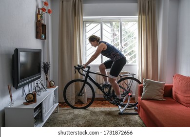 Cyclist woman. She is training on the bike with a smart trainer at home. Stay fit and active while at home.
