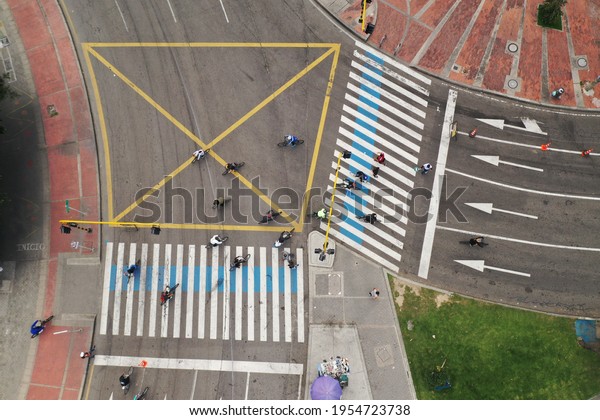 Cyclists crossing a traffic light from one lane to\
the other in Ciclovia in the capital of Colombia. Bogotá Colombia.\
March 21, 2021.