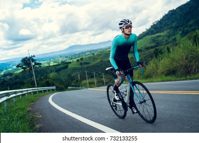 Cyclists are cycling, climbing up to the top.