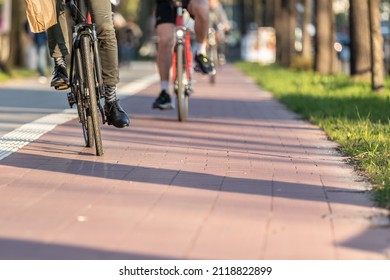 cyclists on a red paved bike path - Shutterstock ID 2118822899