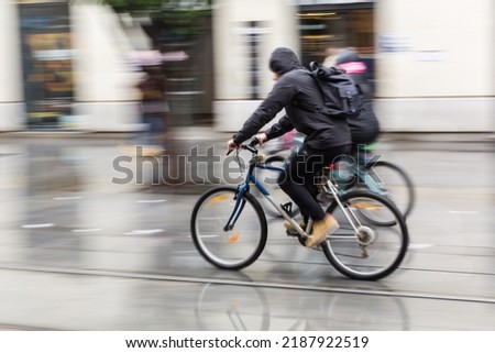 cyclists at rain on the move in the city