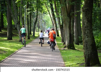 Cyclists Ride Along  Bike Path In Park