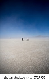 Cyclists Riding Mountain Bikes In The Black Rock Desert In Nevada, USA