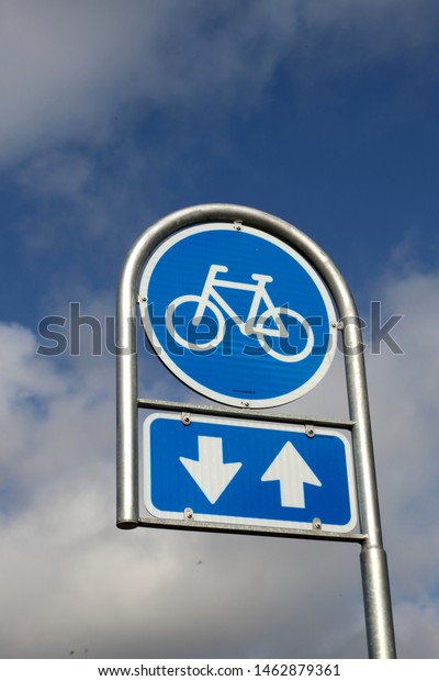 Cyclists traffic sign on\
cloudy sky
