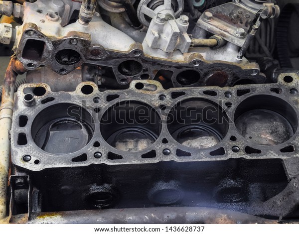 The cylinder block of the four-cylinder engine.
Disassembled motor vehicle for repair. Parts in engine oil. Car
engine repair in the
service.