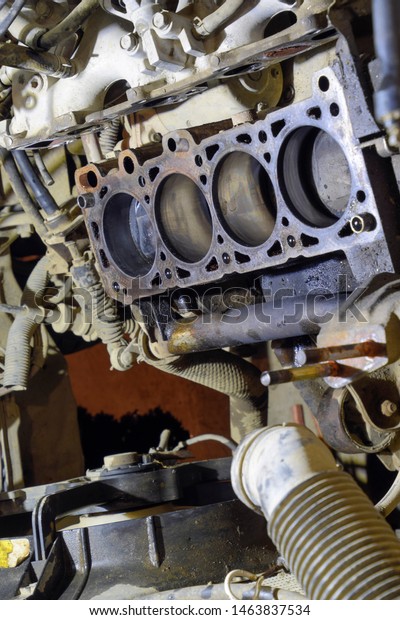 The cylinder block of the four-cylinder engine.\
Disassembled motor vehicle for repair. Parts in engine oil. Car\
engine repair in the\
service.