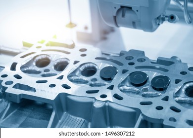 The cylinder head in the assembly process at the automobile factory in the light blue scene. The automotive aluminium casting parts manufacturing process by automatics robotic system .