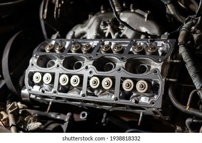 Cylinder head of an auto engine. Inside of a repairing car. Sixteen valves.