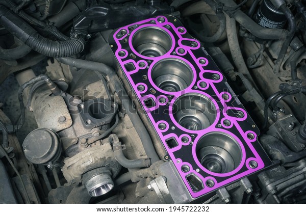 Cylinder head gasket replacement. Repair\
of a turbocharged diesel engine in a car\
workshop.