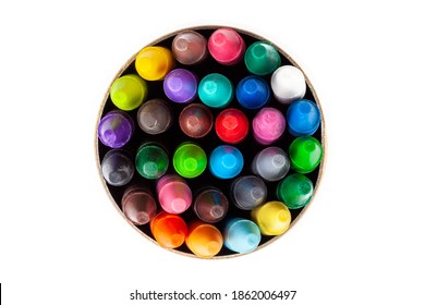 A cylindrical carton tube full of colorful wax crayons seen from above, top view. Lots of multi colored crayons, object isolated on white, cut out. Education, back to school concept, graphical element