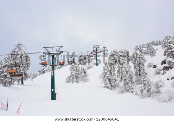 Cyprus Ski lifts and cable\
cars going up the mountain bringing snowboarders to ski\
slopes.