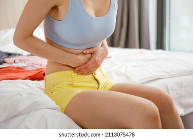 Cystitis in a woman. A young woman has a pain in the lower abdomen, she holds her stomach with her hand.