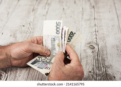 Czech banknotes in a fan in the hands of a trader. Financial concept.Financial concept in Czech currency. business, finance, saving and cash concept - close up of euro paper money and coins on table