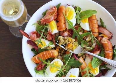 Czech food: traditional czech new year's day lunch in a modern style,  eaten 1st of January to ensure wealth. Green lentils, hard-boiled eggs, sausages, bacon and argula salad on a white plate