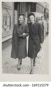 CZECH REPUBLIC, PRAGUE - CIRCA 1940s: Vintage Photo Of Two Young Women Walking On Street, Prague, Czech Republic, Circa 1940s