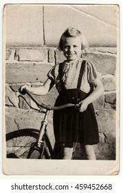 THE CZECHOSLOVAK REPUBLIC - CIRCA 1950s: Vintage photo shows a small girl with bicycle.  Retro black & white photography.