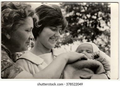 THE CZECHOSLOVAK SOCIALIST REPUBLIC - 1960s: Vintage photo shows young woman (mother) cradles baby. Grandmother looks at baby.